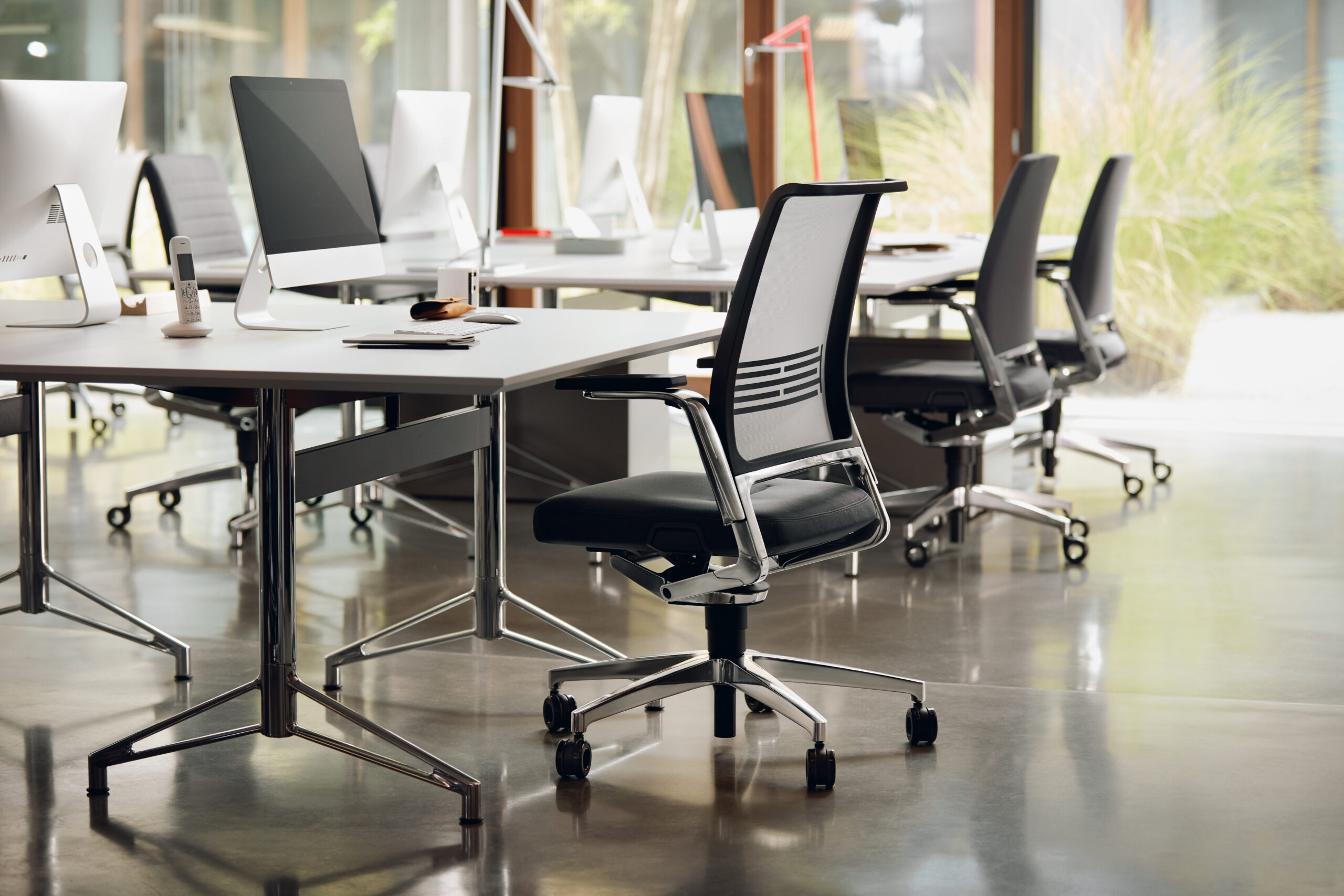 Ergonomic office setup with adjustable tables and chairs for comfort