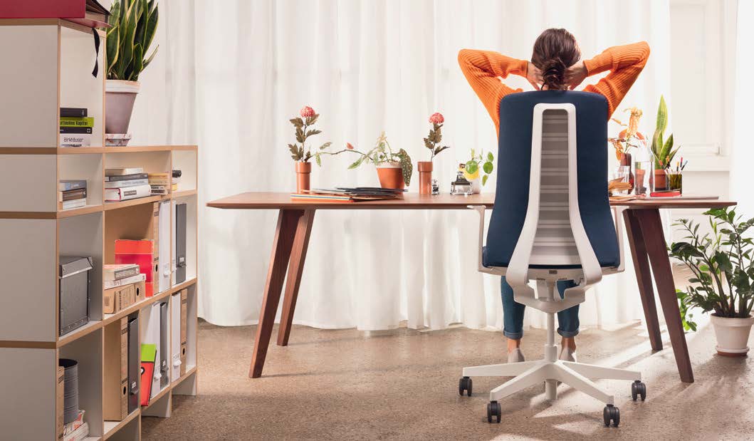 Ergonomic office setup with adjustable tables and chairs for comfort